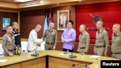 FILE - Chinese actor Wang Xing, third from left, shakes hands with a Thai police officer following his return after being kidnapped into a Myanmar telecom fraud center, at a police station in the Mae Sot district, Thailand, on Jan. 7, 2025. (Royal Thai Police via Reuters)