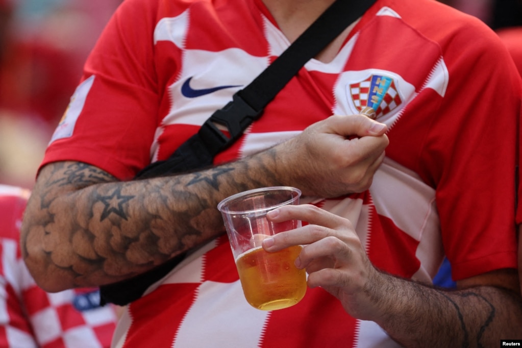 A dos días para el comienzo del Mundial de Fútbol, el Gobierno de Qatar sorprendió a la FIFA y a los aficionados al prohibir la venta de alcohol tanto en los estadios como en sus alrededores, permitiendo finalmente su consumo en la Fan Zone. En esta imagen, un seguidor de Croacia se agarra el escudo de la camiseta con una mano mientras con la otra sostiene una cerveza sin acohol, en el estadio Al Bayt, en Al Khor, Qatar, el 23 de noviembre de 2022.