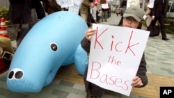 FILE - Protesters use an inflatable dugong during a rally opposing the U.S. military base relocation in Okinawa, outside Japan's defense agency in Tokyo, April 8, 2006. The Center for Biological Diversity argues that U.S. officials failed to adequately consider the base's effects on the Okinawa dugong, an endangered marine mammal that resembles a manatee.