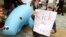 FILE - Protesters use an inflatable dugong during a rally opposing the U.S. military base relocation in Okinawa, outside Japan's defense agency in Tokyo, April 8, 2006. The Center for Biological Diversity argues that U.S. officials failed to adequately consider the base's effects on the Okinawa dugong, an endangered marine mammal that resembles a manatee.