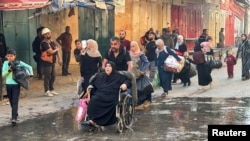 Displaced Palestinians ordered by the Israeli military to evacuate their neighborhoods make their way as they flee amid an Israeli military operation, in Beit Lahiya in the northern Gaza Strip, Oct. 22, 2024.