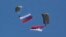 FILE - Serbian soldiers parachute from a Mi-8 transport helicopter with a Russian, left, and Serbian flags during joint Russian-Serbian military exercices at Nikinci training ground, 60 kilometers west of Belgrade, Serbia, Nov. 14, 2014.