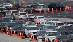 Lines of cars wait at a drive-through coronavirus testing site, Sunday, July 5, 2020, outside Hard Rock Stadium in Miami Gardens, Fla.