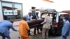 South Africa undertakers load a casket on a hearse