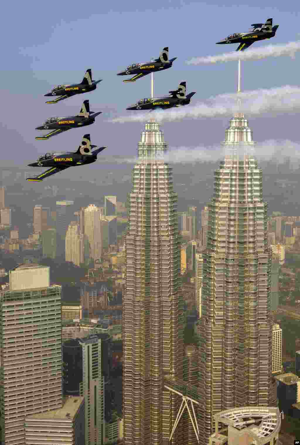 The Breitling Jet Team flies over the Petronas Towers less than 3 metres apart above Kuala Lumpur, Malaysia. The ambassadors for the Swiss luxury watch company Breitling are due to visit Korea and Japan before returning to their home base in Europe.