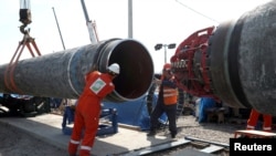 FILE - Workers are seen at the construction site of the Nord Stream 2 gas pipeline, near the town of Kingisepp, Leningrad region, Russia, June 5, 2019. 