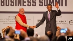U.S. President Barack Obama, right waves to the audience as he and Indian Prime Minister Narendra Modi attend the India-U.S business summit in New Delhi, India, Jan. 26, 2015. 