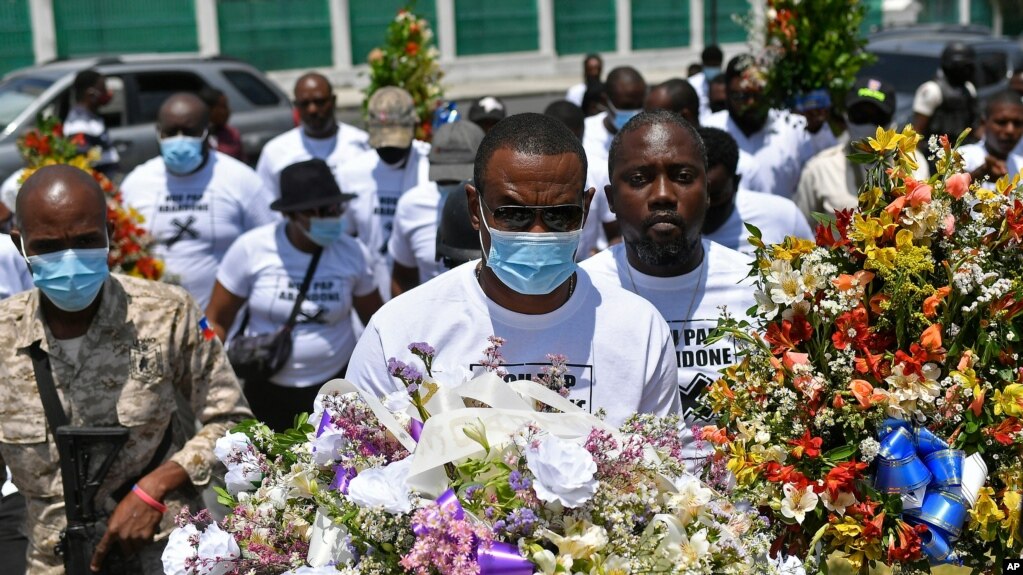 遇刺海地总统莫伊兹的政党PHTK的成员在总统府外持花悼念。(2021年7月14日)(photo:VOA)