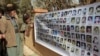 FILE - In this March 16, 2008 file photo, Kurds look at images of the victims of Halabja massacre in Halabja, Iraq.