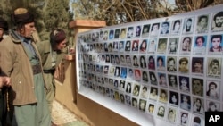 FILE - In this March 16, 2008 file photo, Kurds look at images of the victims of Halabja massacre in Halabja, Iraq.