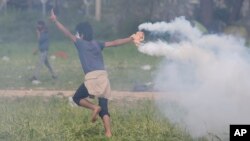 یکی از مهاجران، کپسول گاز اشک آور را به سمت پلیس مقدونیه پرتاب می کند - ۲۲ فروردین ۱۳۹۵