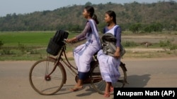 Indian girls go to a school on a bicycle at Roja Mayong village about 40 kilometers (25 miles) east of Gauhati, India. 