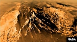 Titan is seen from the Huygens probe as it descended to the surface in 2005.