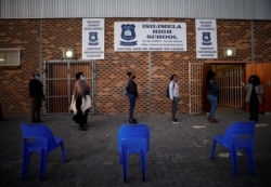 FILE - Teachers practice social distancing before being screened after the coronavirus disease lockdown in Cape Town, South Africa, June 8, 2020.
