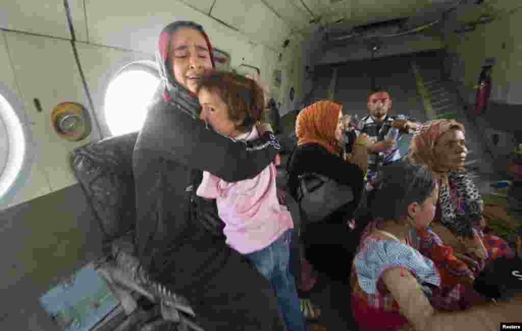 A woman holding a child reacts in a military helicopter after being evacuated by Iraqi forces from Amerli, north of Baghdad, Aug. 29, 2014.