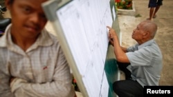 A man checks voter lists at a polling station in a Phnom Penh suburb July 27, 2013.