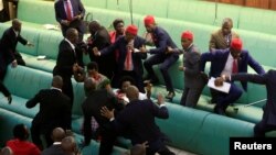 Ugandan opposition lawmakers fight with plain-clothes security personnel in the parliament while protesting a proposed age limit amendment bill debate to change the constitution for the extension of the president's rule, in Kampala, Sept. 27, 2017.