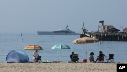 Early beachgoers secure spots on the shore at Santa Barbara, Calif., on Sunday, Aug. 16, 2020.