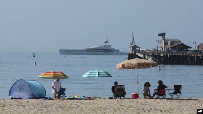 Early beachgoers secure spots on the shore at Santa Barbara, Calif., on Sunday, Aug. 16, 2020.