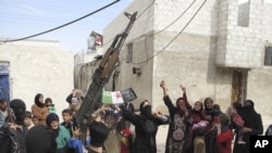 In this Sunday, April 1, 2012 photo, Syrians chant slogans against President Bashar Assad upon the arrival of the Free Syrian Army in a neighborhood of Damascus, Syria. Government and opposition forces clashed across Syria Monday as international envoy Ko