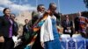 Navajo Nation President Ben Shelly (L) puts a blanket on the shoulders of U.S. Interior Secretary Sally Jewell after a ceremonial signing of a record multi-million-dollar settlement, in Window Rock, Arizona, at the Navajo Nation, Sept. 26, 2014.
