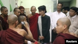 Birma muxolifati yetakchisi Aun San Su Chi mis koniga qarshi namoyishda qatnashgan buddist rohiblari bilan uchrashmoqda, 29-noyabr, 2012-yil.