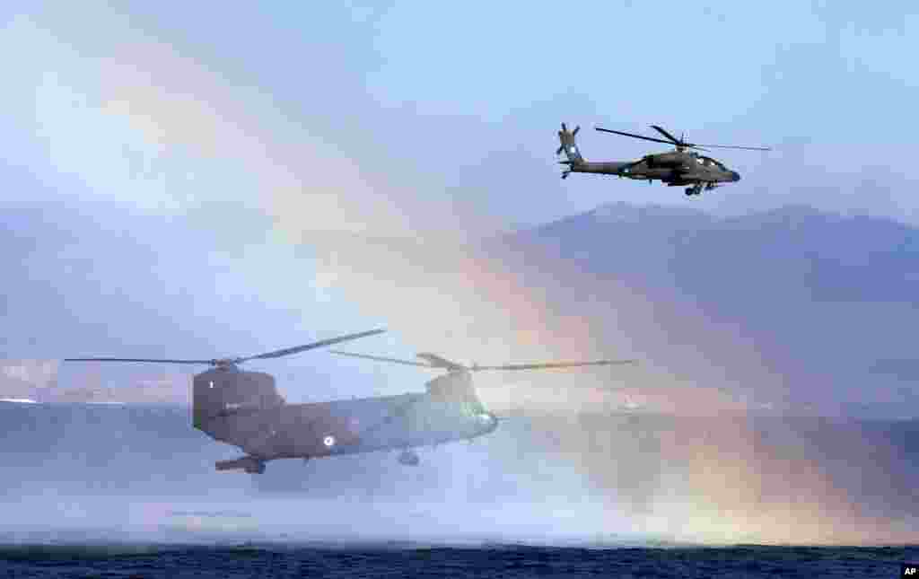 Pelangi muncul saat helikopter NATO berpartisipasi dalam latihan militer&nbsp;&#39;&#39;Pyrpolitis&#39;&#39; di Teluk Saronic, selatan&nbsp;Athena, Yunani. 