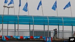 Men walk on a crossover bridge with flags of Malaysia's ruling party National Front on display for the upcoming general elections, in Kapar, outside Kuala Lumpur, Malaysia, April 10, 2013.