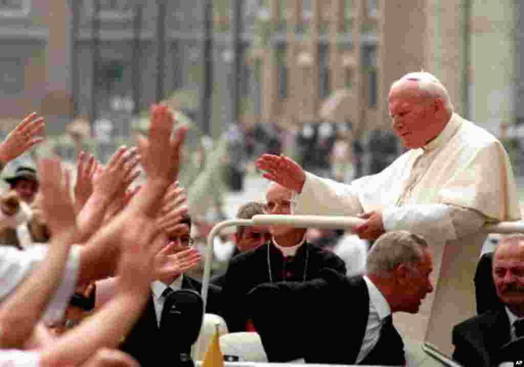 Pope John Paul II greets some of the approximately 6,000 Polish faithful gathered in Saint Peter's Square at the Vatican for a special outdoor audience on June 4, 1998, on occasion of the anniversary of his trip to Poland in June ,1997 (AP Photo/Massimo S