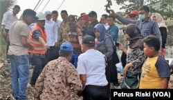 Gubernur Jawa Timur Khofifah Indar Parawansa berdialog dengan warga dan pejabat setempat di atas tumpukan sampah plastik di Desa Bangun, Kecamatan Pungging, Kabupaten Mojokerto, 19 Juni 2019. (Foto: Petrus Riski/VOA)