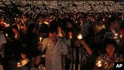 Christians hold candles during a Christmas mass at the Gelora Bung Karno stadium in Jakarta, 11 Dec 2010