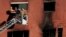 Firefighters load the body of a dead person into a crane after a fire on a building in Badalona, Barcelona, Spain, Dec. 10, 2020. 