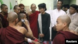 Burmese pro-democracy leader Aung San Suu Kyi visits Buddhist monks, wounded in a police crackdown on activists fighting a Chinese copper mine project, at a hospital in Monywa, Nov. 29, 2012. 