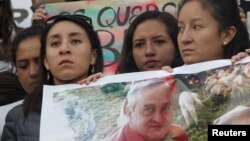 Friends and relatives hold a photograph of Efrain Segarra, who was kidnapped near the Colombian border with Ecuadorean journalists Paul Rivas and Javier Ortega (both not pictured), in Quito, Ecuador, April 1, 2018.