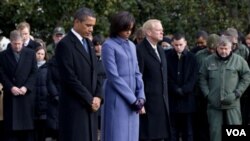 El presidente Barack Obama, la primera dama, Michelle Obama y miembros del equipo de los congresistas durante el minuto de silencio en el Capitolio.