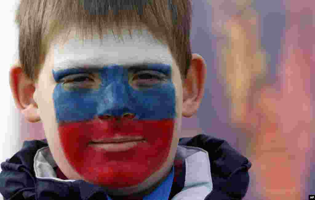 Limonov Egor Dmitrievich wears face paint in the colors of the Russian flag at the 2014 Winter Olympics in Sochi, Russia. 