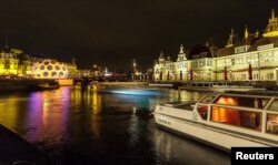 FILE - A tourist boat passes on a canal in Amsterdam, Dec. 6, 2013.