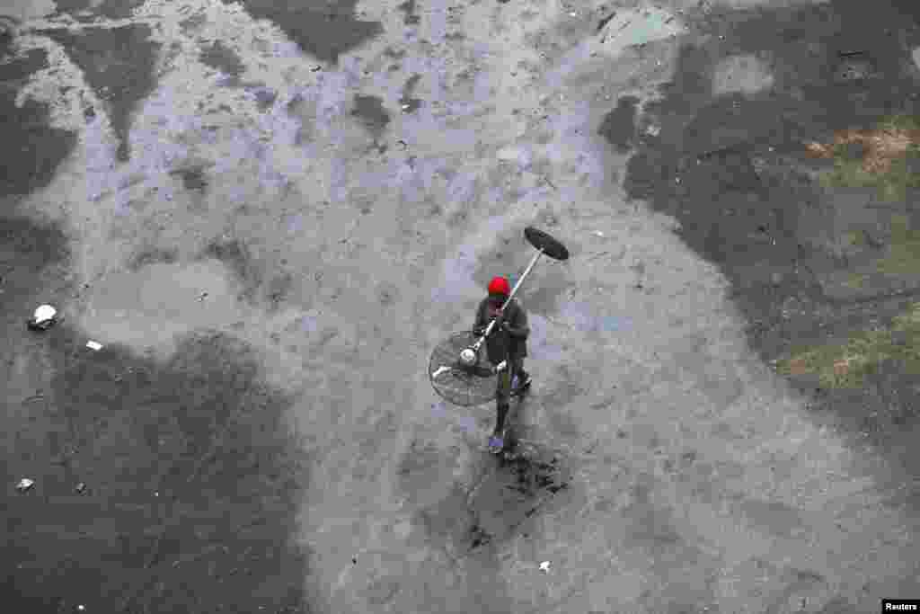 A man carries a broken fan as he walks through an automobile workshop at the Orile-Iganmu district in Lagos.