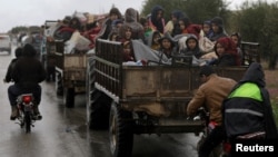 People sit in a truck with their belongings in the north east of Afrin, Syria, March 15, 2018. 