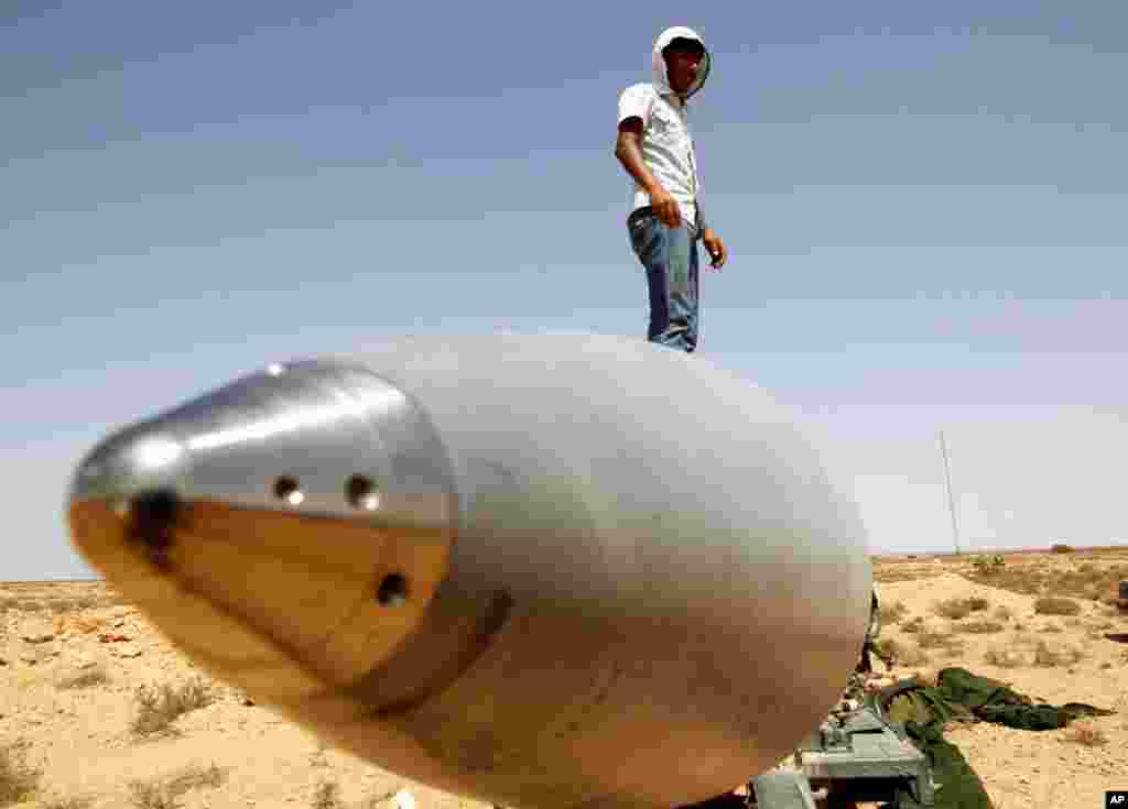 September 1: An anti-Gaddafi fighter stands on an SA-5 SAM missile in Burkan air defense military base, which was destroyed by a NATO air strike. REUTERS/Goran Tomasevic