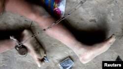 FILE - Mentally challenged Shomvu Sharkar, 8, is chained inside his hut in the northeastern Indian city of Siliguri.