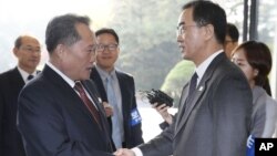 Ri Son Gwon, ketua Komite Reunifikasi Damai Korea Utara (kiri) berjabat tangan dengan Menteri Unifikasi Korea Selatan Cho Myoung-gyon sebelum pertemuan di Panmunjom, Senin (15/10). 