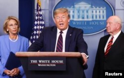 U.S. President Donald Trump addresses the daily coronavirus response briefing as Education Secretary Betsy DeVos and Agriculture Secretary Sonny Perdue listen at the White House in Washington, U.S., March 27, 2020. REUTERS/Jonathan Ernst