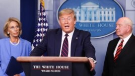 U.S. President Donald Trump addresses the daily coronavirus response briefing as Education Secretary Betsy DeVos and Agriculture Secretary Sonny Perdue listen at the White House in Washington, U.S., March 27, 2020. REUTERS/Jonathan Ernst