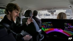 In this photograph taken on April 10, 2017, Luminar CEO Austin Russell gestures while looking at a 3D lidar map on a demonstration drive in San Francisco. 