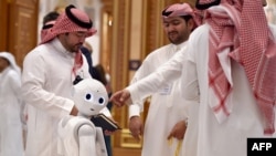 在沙特阿拉伯首都利雅得阿卜杜勒阿齐兹国王会议中心举行的未来投资倡议论坛上，代表们在机器人旁交谈。（2019年10月31日）