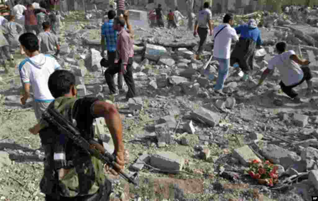 Warga Suriah memeriksa kerusakan setelah serangan udara menghancurkan setidaknya 10 rumah di kota Azaz di pinggiran kota Aleppo, Suriah (15/8).