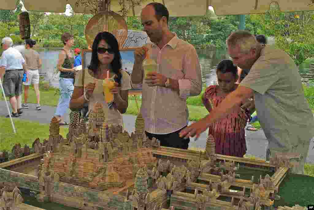 Participants carefully studying a replica of Angkor Wat, Cambodia's famed medieval temple. The 5,000-dollar replica was commissioned from Cambodia.