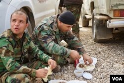 Peshmerga fighters who were eating were interrupted by more fighting as jihadists emerged from nearby tunnels Bashiqa, Iraq, Nov. 8, 2016. (J. Dettmer/VOA)