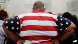 FILE - In this May 8, 2014 photo, an overweight man wears a shirt patterned after the American flag during a visit to the World Trade Center, in New York. 